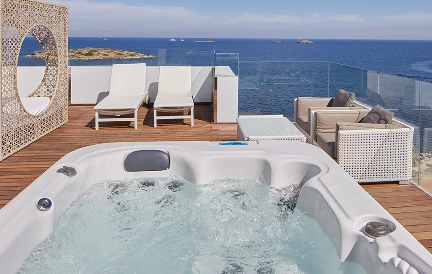 Terraza amueblada y con sillones y con un jacuzzi privado con vistas al mar